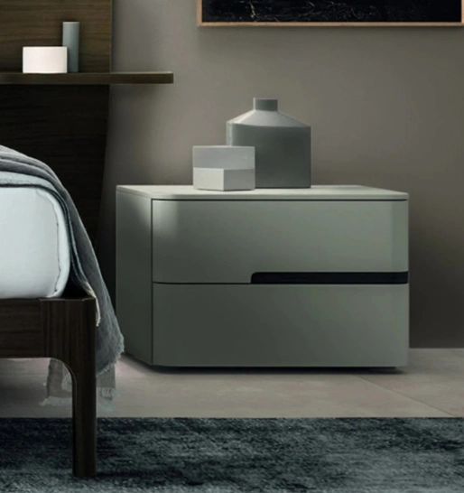 A green-finish bedside end table with a curved design, two drawers, decorated with vases & a small cube