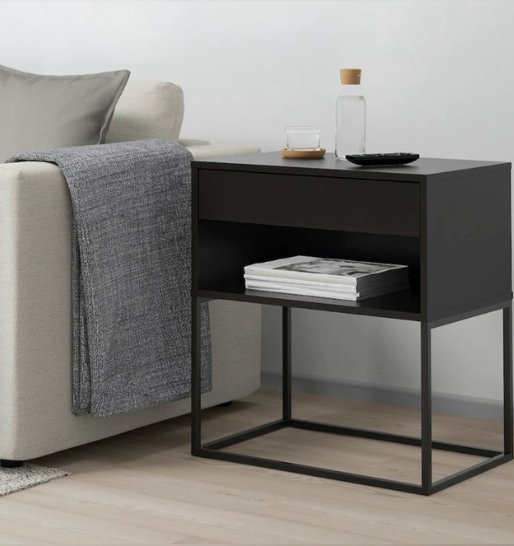 A modern black side table with magazines beside a gray-colored sofa on a wooden floor with amazing design