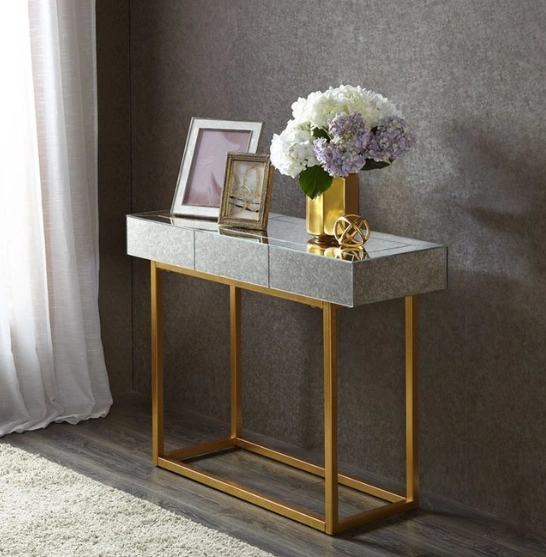 A gold console table with a vibrant flower arrangement showing elegance and style in home decor.